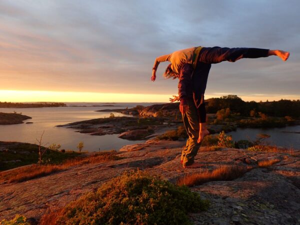 A person dancing in front of an impressive landscape