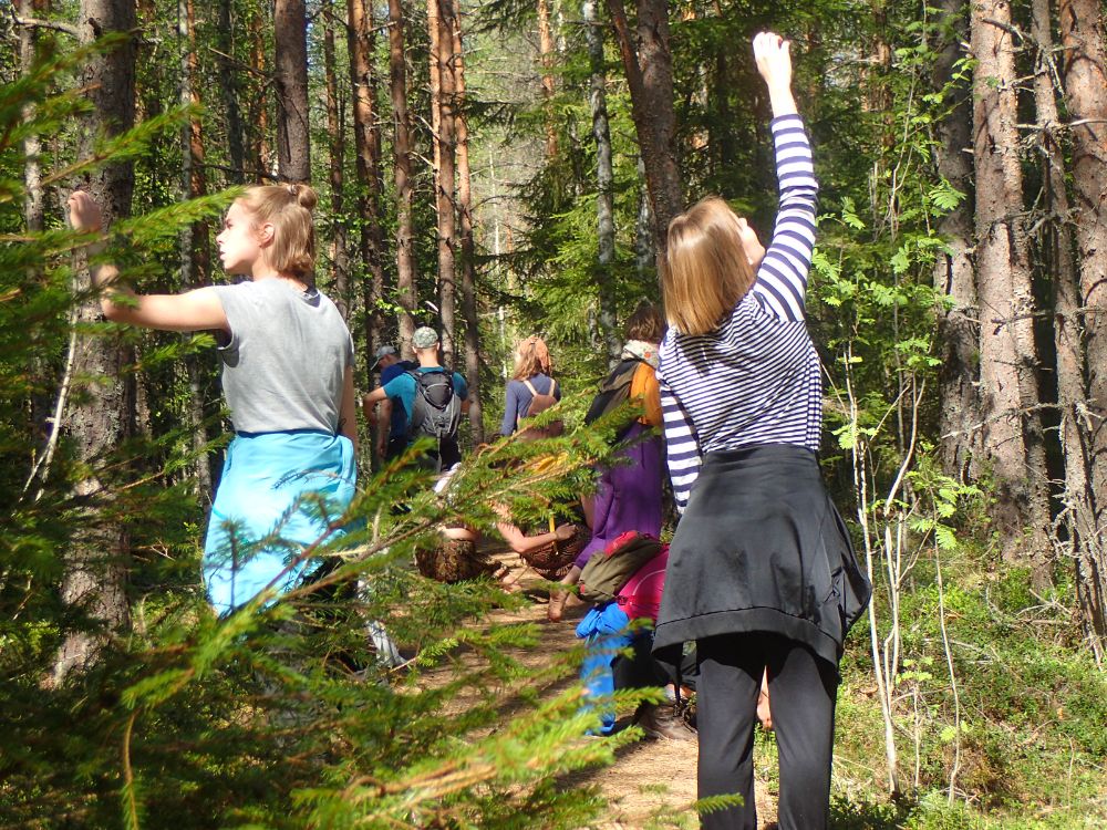 Ryhmä ihmisiä tanssii metsässä