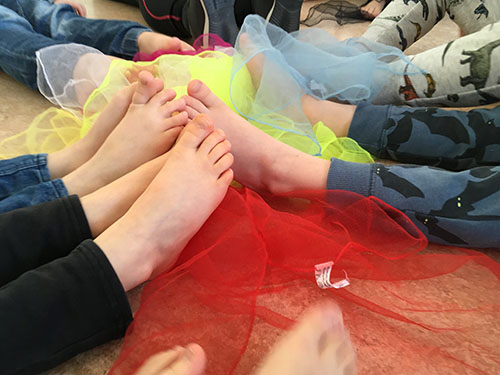 Barnens fötter och en serie färgglada tyger