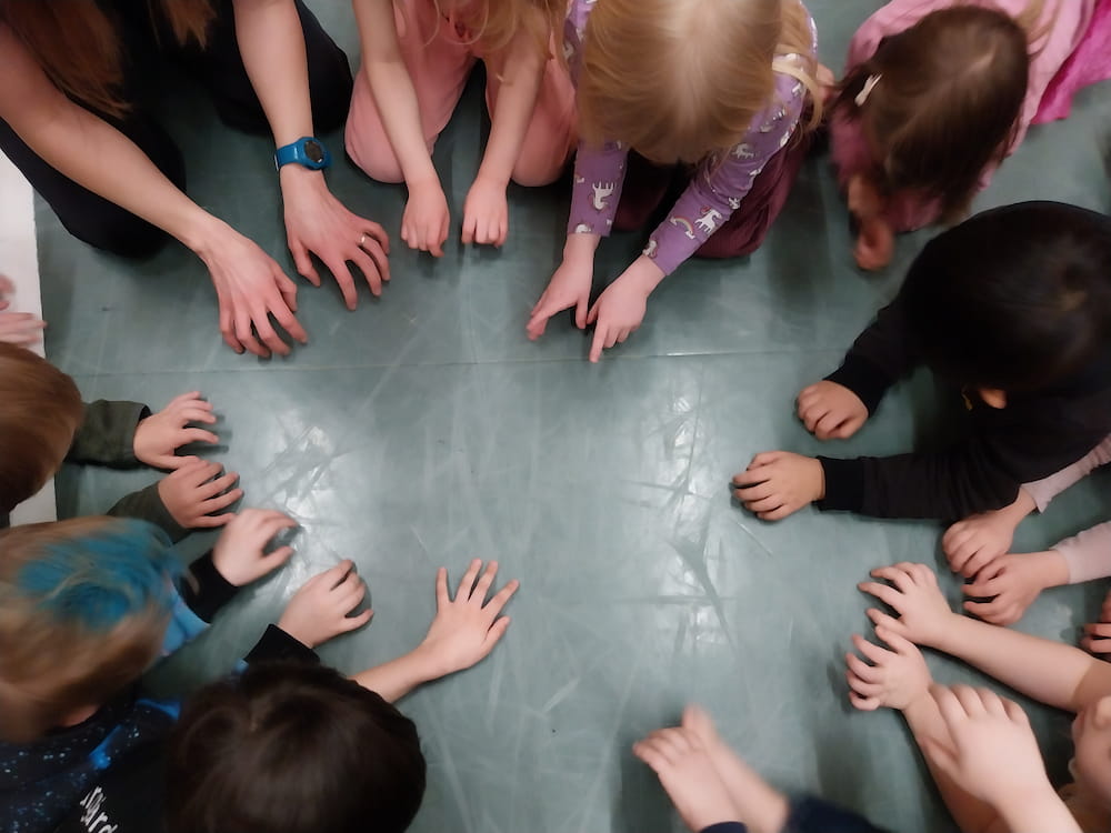 En cirkel av barn som leker på golvet