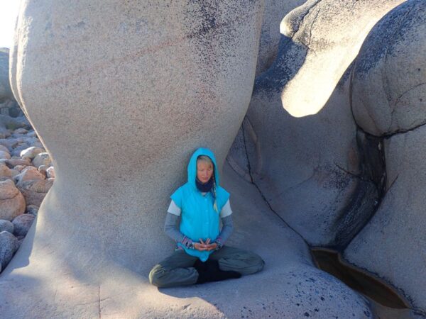 ElinMaria mediterar på en vacker klippformation