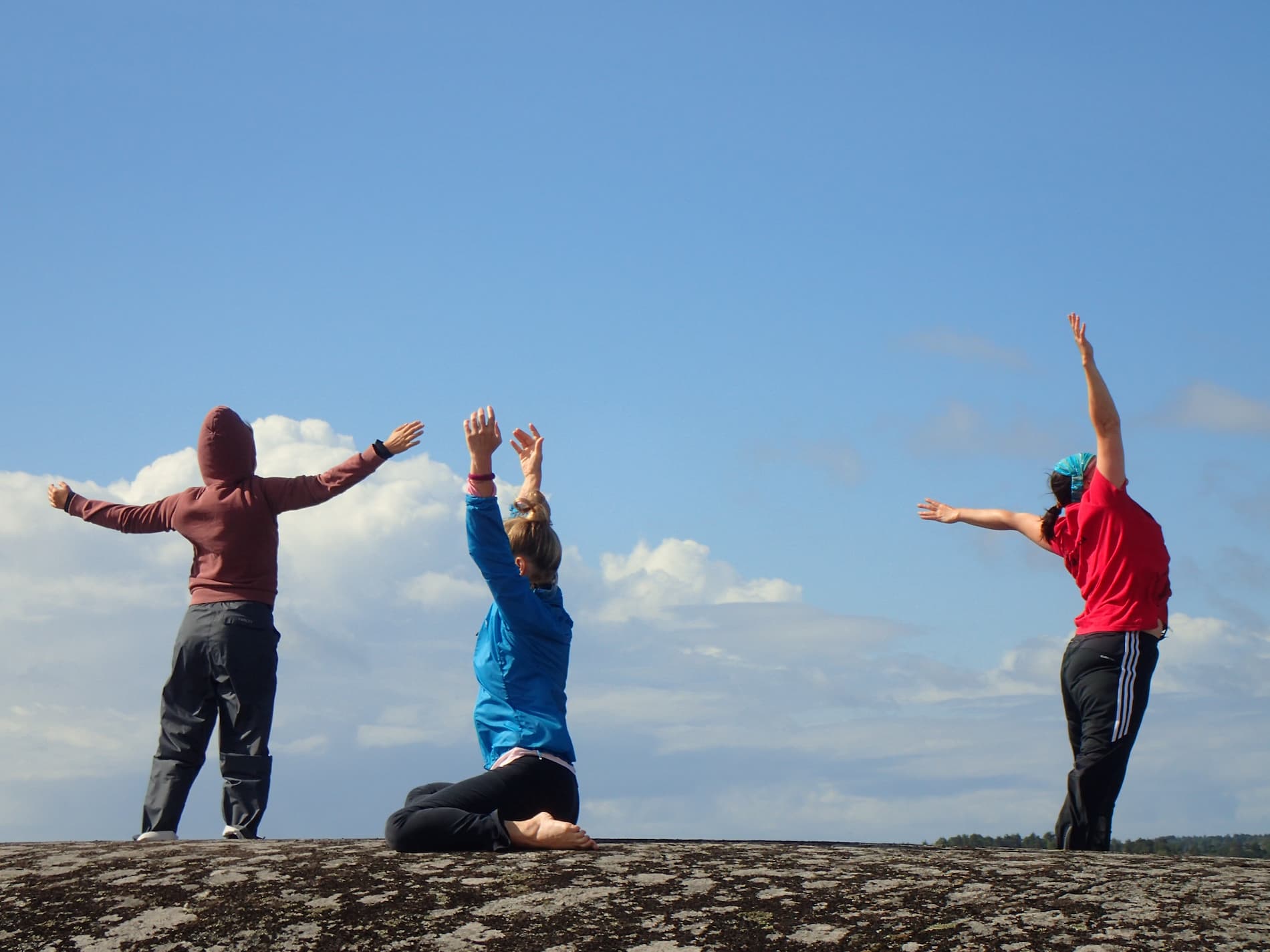 En grupp människor dansar på toppen av en sten.